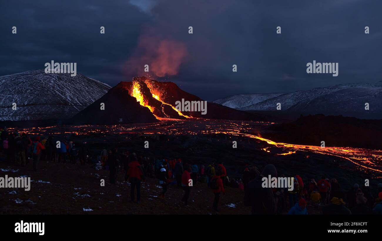 Persone che osservano recentemente eruttato vulcano a Fagradalsfjall nelle valli di Geldingadalir con espulsione di lava, flussi di lava incandescente e fumi. Foto Stock