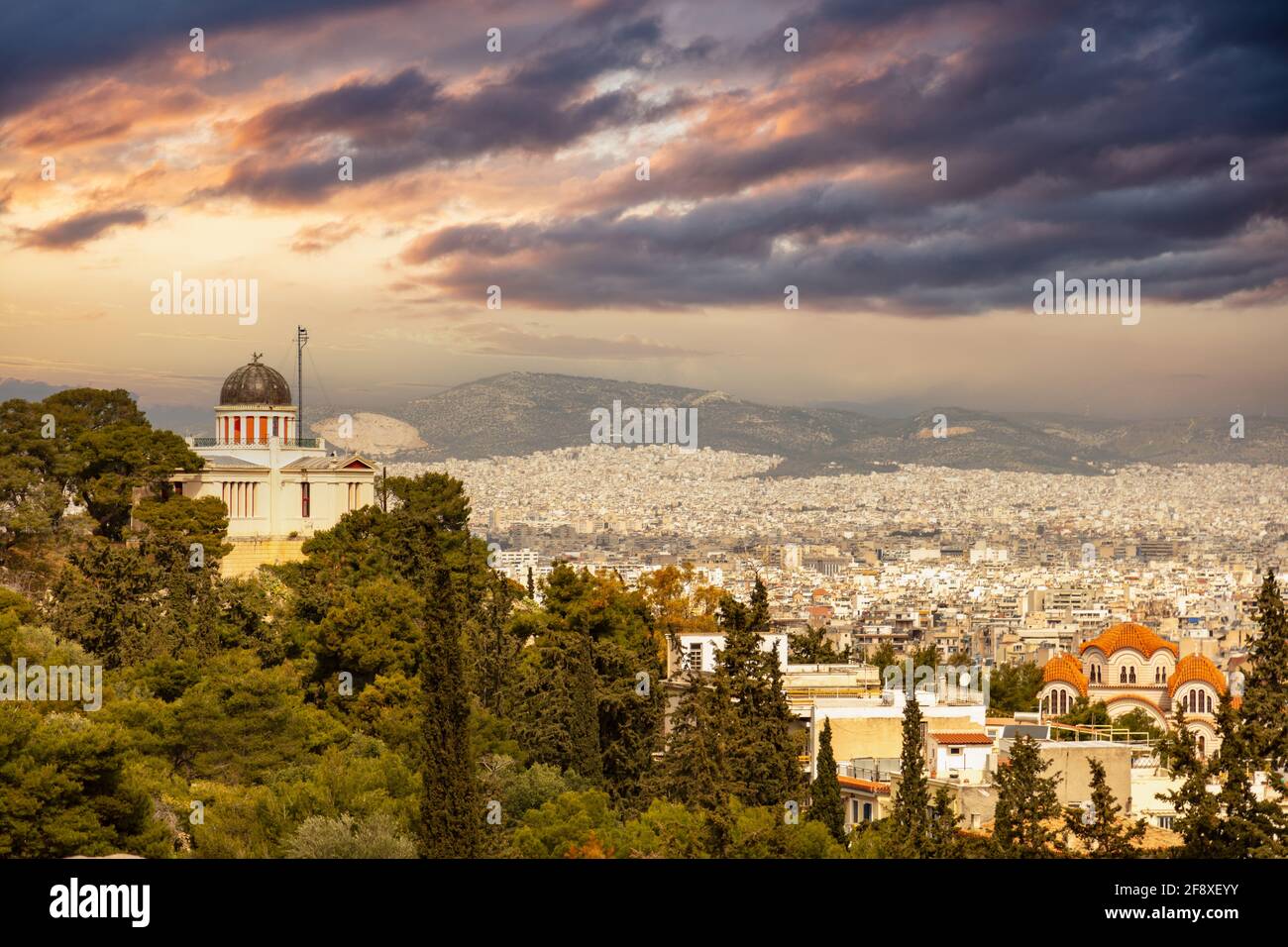 Atene, Grecia. L'osservatorio nazionale si trova su una collina, il paesaggio urbano di Atene, il cielo con le nuvole al tramonto, la vista dalle strade di Plaka Foto Stock