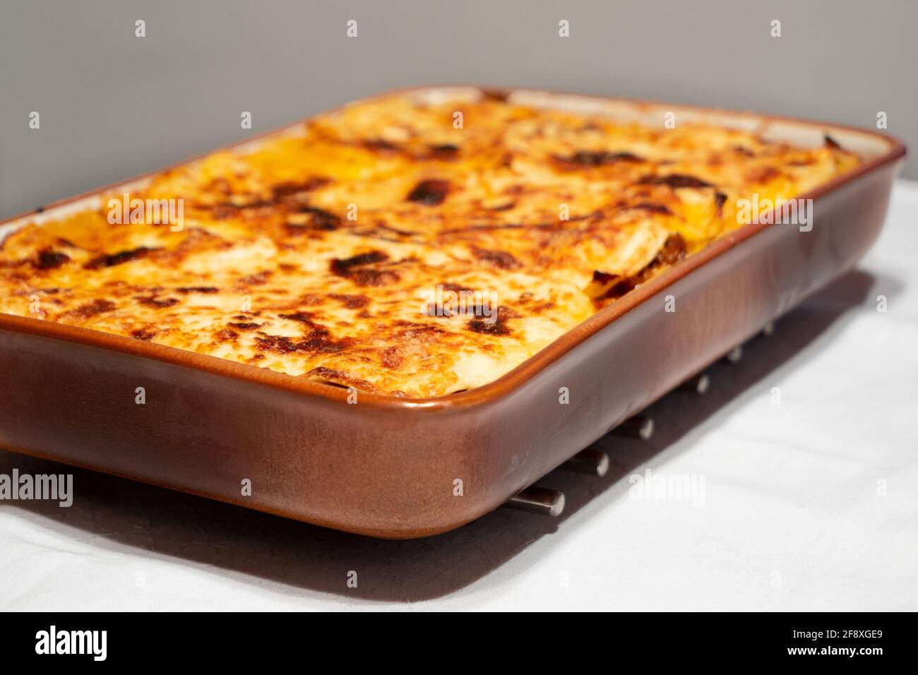 Lasagna alla Bolognese, al forno con ragu di carne su un piatto bianco servito come un'intera famiglia stile Foto Stock