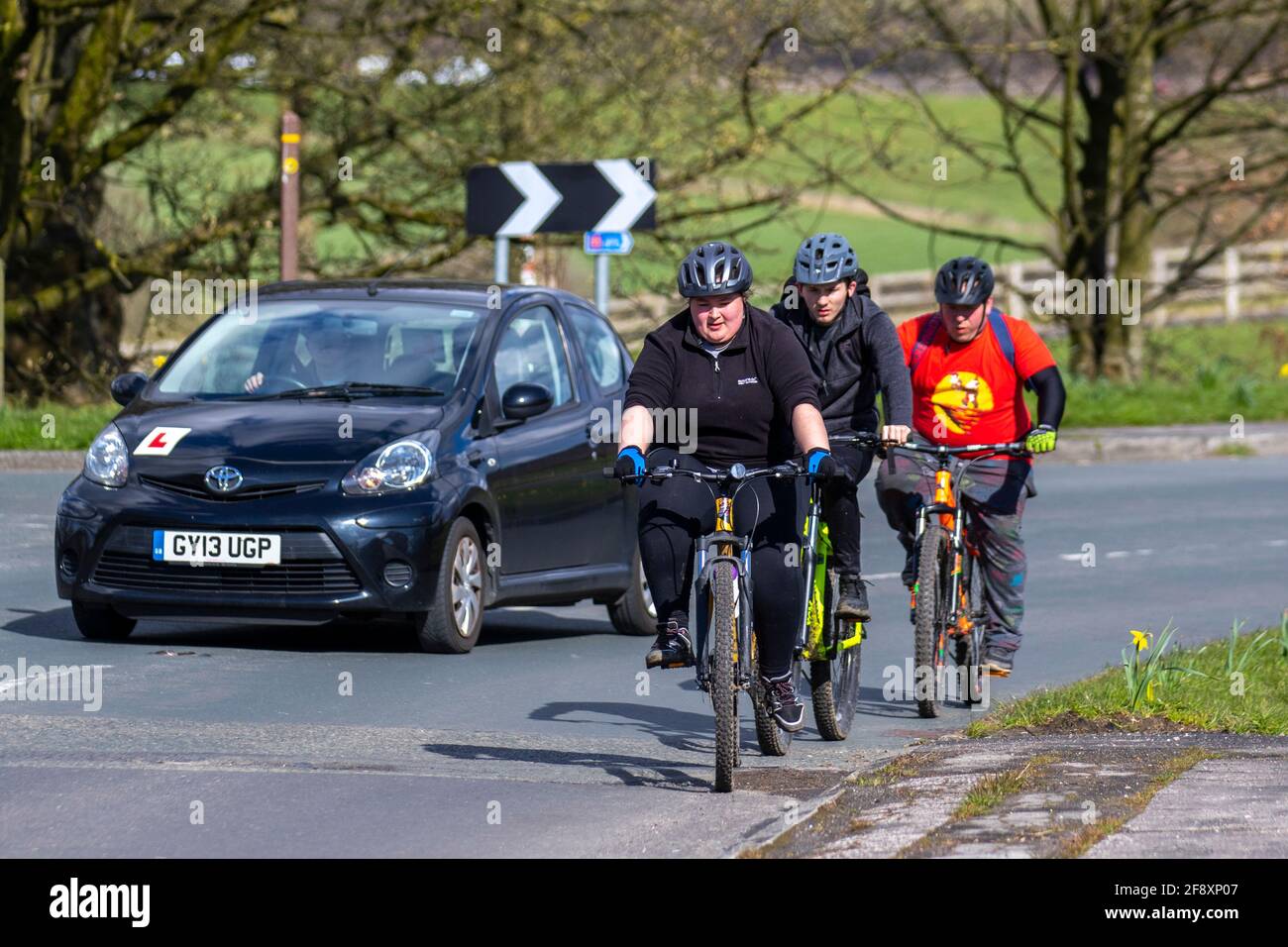 Ciclisti in sorpasso; sorpasso di un ciclista, sorpasso di un veicolo, passaggio di veicoli lenti, regola 188 del codice stradale per sorpassi ciclisti su strada. Foto Stock