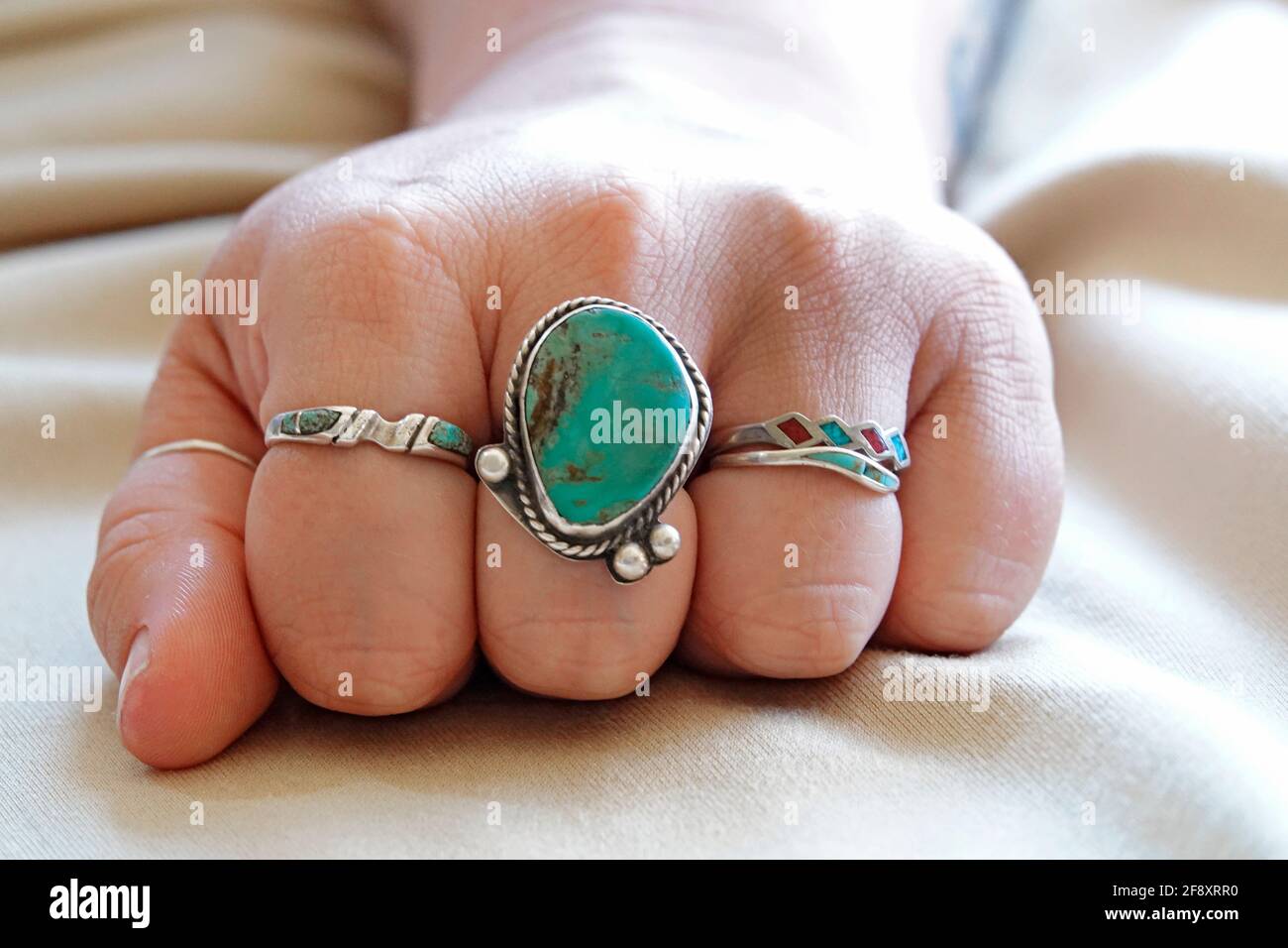 Una selezione di anelli turchesi e argentati, realizzati da indiani del  sud-ovest degli Stati Uniti, su una mano di donna Foto stock - Alamy