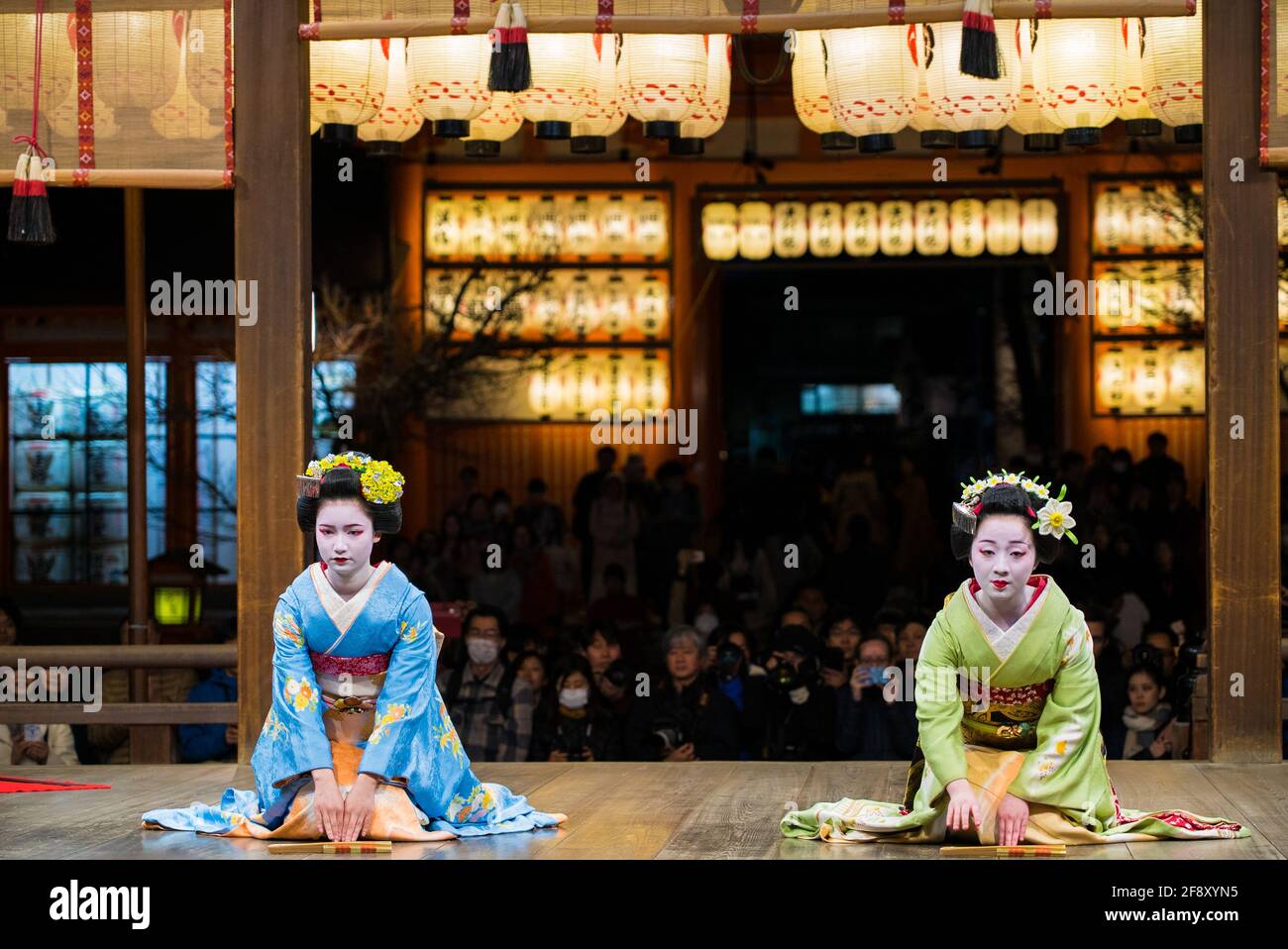 Geisha indossando kimono danzando e suonando sul palco di fronte al pubblico. Bella ed elegante maiko. Santuario di Yasaka, Kyoto, Giappone. Foto Stock