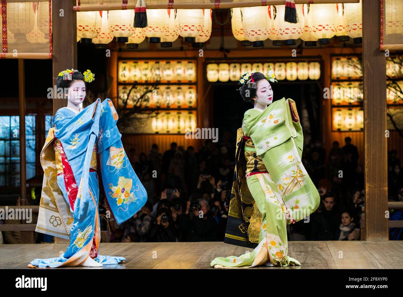 Geisha indossando kimono danzando e suonando sul palco di fronte al pubblico. Bella ed elegante maiko. Santuario di Yasaka, Kyoto, Giappone. Foto Stock