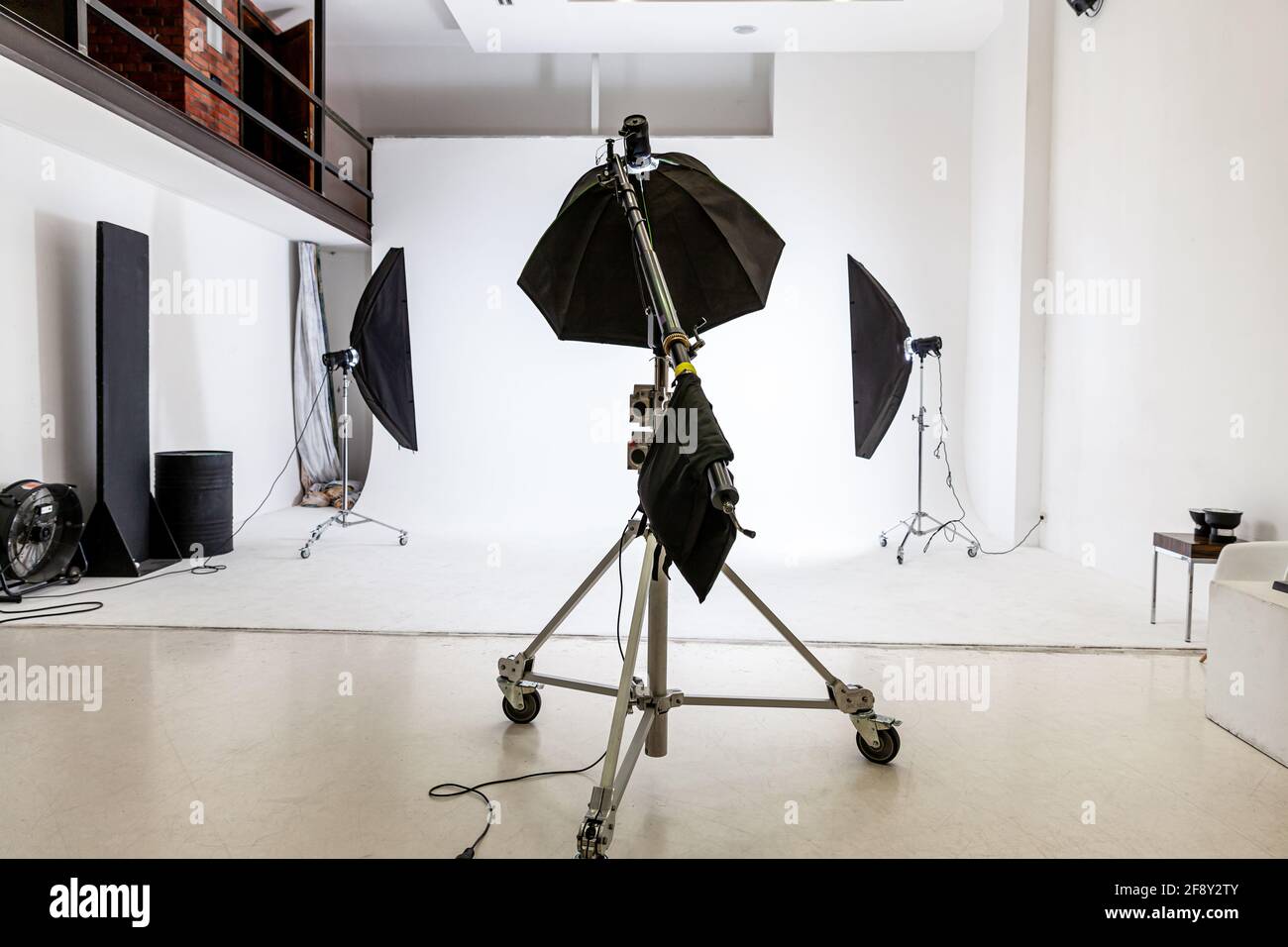 Studio fotografico vuoto con apparecchiature di illuminazione. Interni per il luogo di lavoro dei fotografi con set di attrezzi professionali. Flash light, sfondo bianco scene leggere Foto Stock
