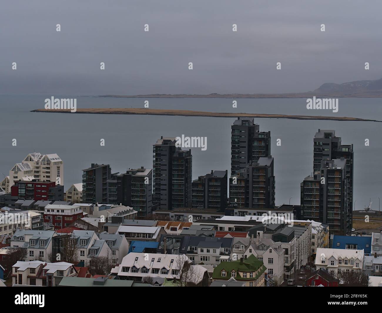 Vista aerea sulla parte ovest del centro di Reykjavik con edifici residenziali, tra cui un alto edificio di appartamenti di colore nero sulla costa. Foto Stock