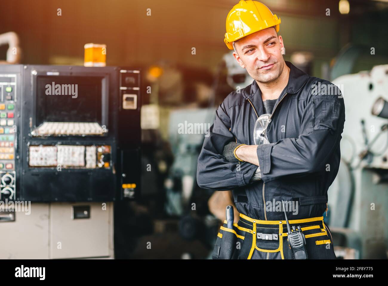 Sicurezza lavoratore di Smart ENGINEER, ritratto bello con tuta di sicurezza con macchina industriale pesante in fabbrica. Foto Stock