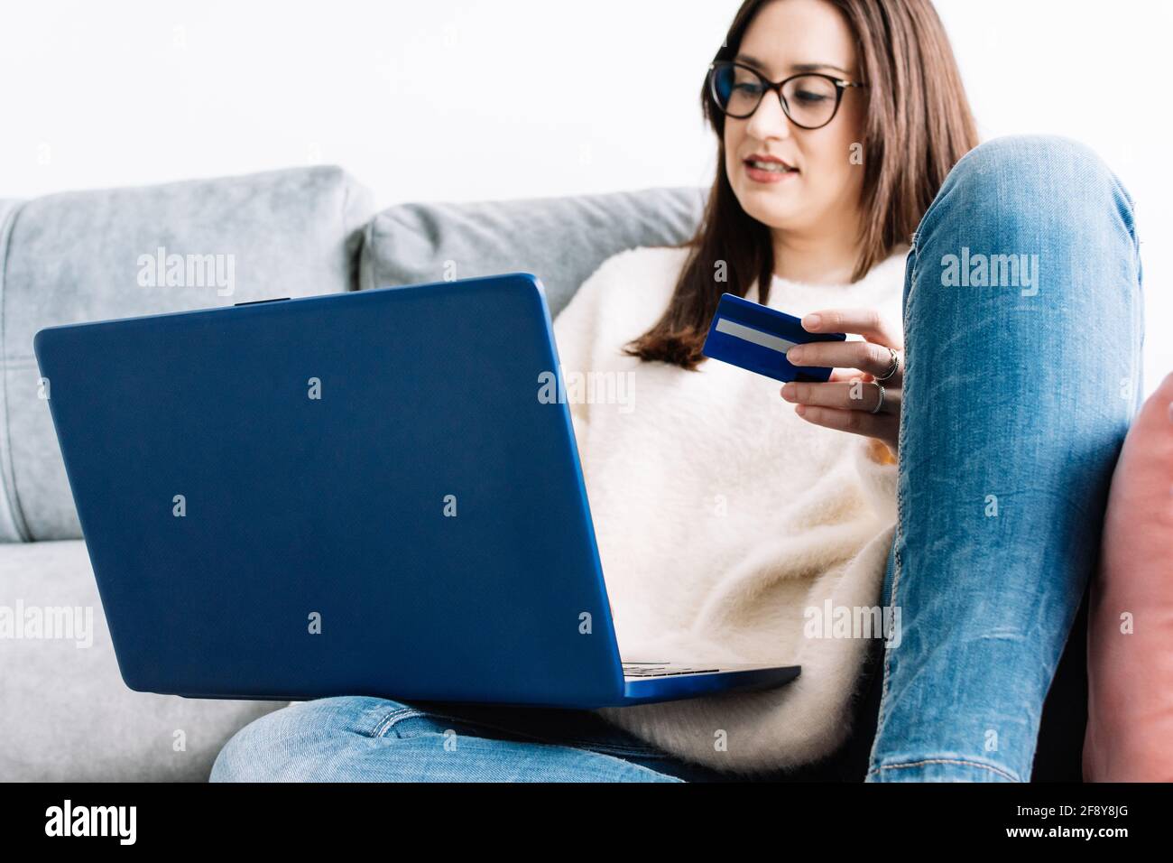 donna che usa una carta di credito per fare acquisti online da casa Foto Stock
