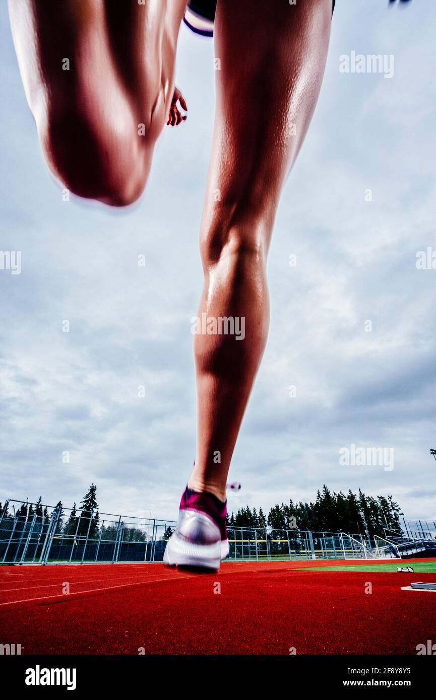 Sezione bassa di donna che corre in pista Foto Stock