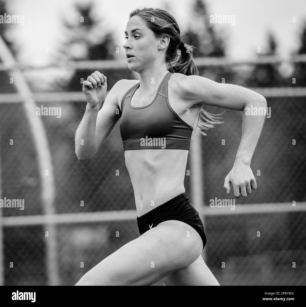 Giovane donna che corre in pista Foto Stock