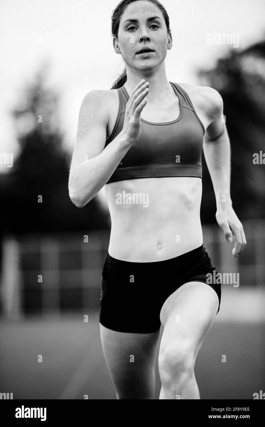 Giovane donna che corre in pista Foto Stock