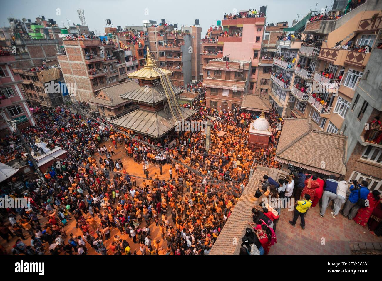 Bhaktapur, Nepal. 15 Aprile 2021. I popoli della comunità newari suonano strumenti tradizionali mentre gettano polvere di vermiglio (coperto) l'uno verso l'altro durante il festival indoor Jatra. I rivelatori portarono carri degli dei e delle dea indù e si gettarono vermilioni di polvere l'uno sull'altro come parte delle celebrazioni che iniziarono il nuovo anno nepalese. Credit: SOPA Images Limited/Alamy Live News Foto Stock