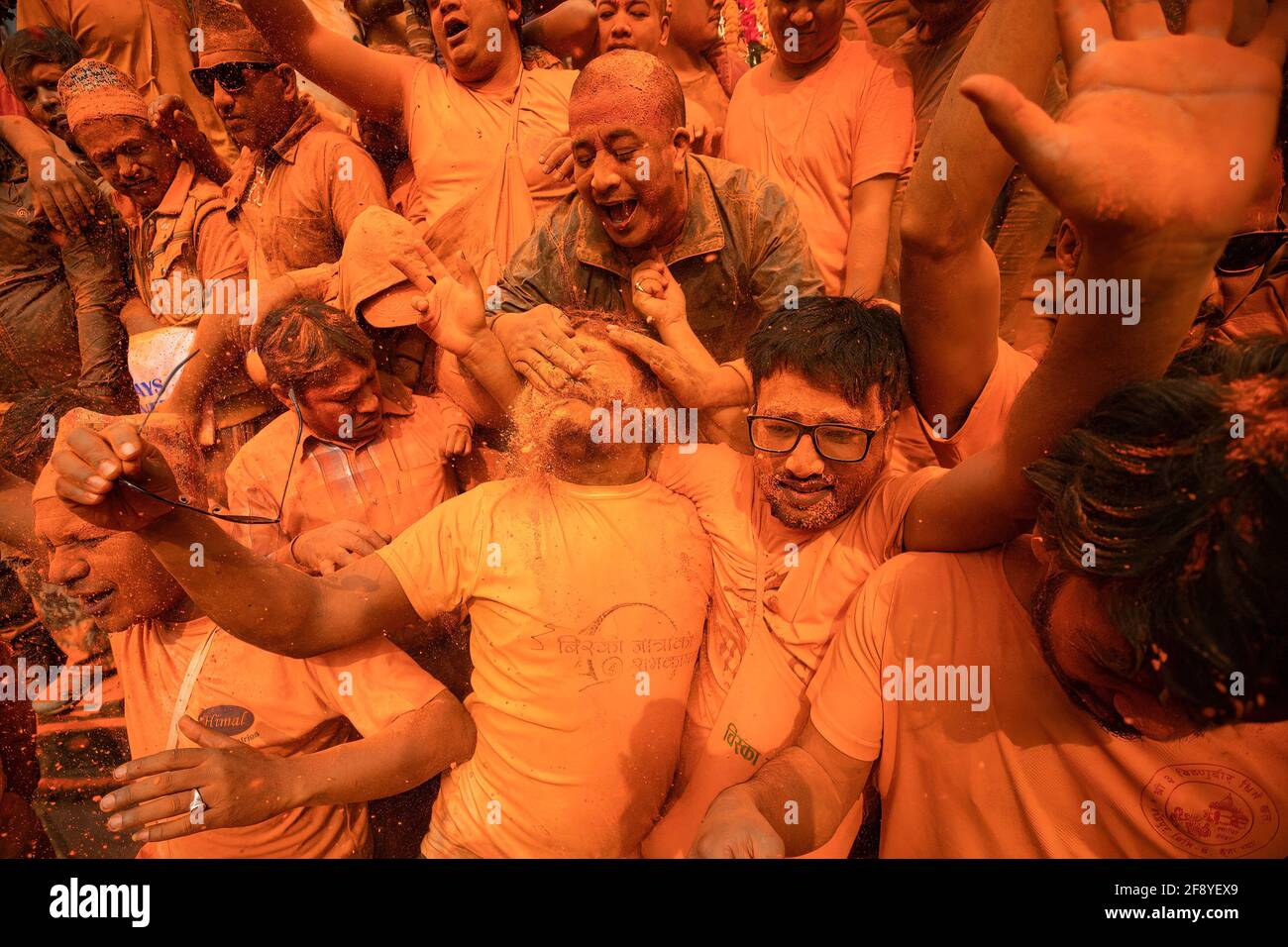 Bhaktapur, Nepal. 15 Aprile 2021. I devoti giocano con polvere di vermiglio mentre celebrano il festival della polvere di vermillion di Jatra. I rivelatori portarono carri degli dei e delle dea indù e si gettarono vermilioni di polvere l'uno sull'altro come parte delle celebrazioni che iniziarono il nuovo anno nepalese. Credit: SOPA Images Limited/Alamy Live News Foto Stock
