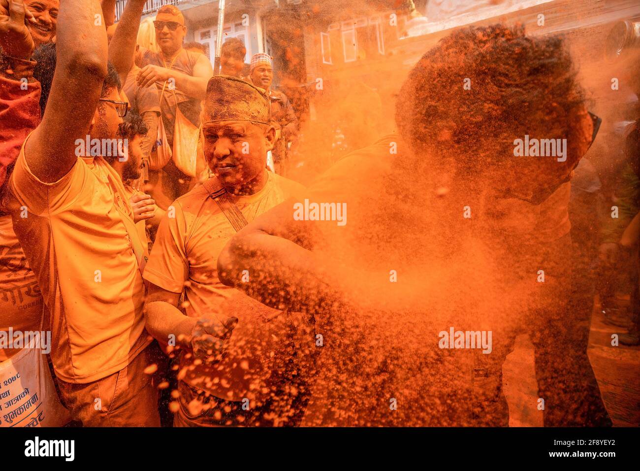 Bhaktapur, Nepal. 15 Aprile 2021. I devoti coperti di polvere di vermiglio celebrano il festival della polvere di 'Indoor Jatra'. I rivelatori portarono carri degli dei e delle dea indù e si gettarono vermilioni di polvere l'uno sull'altro come parte delle celebrazioni che iniziarono il nuovo anno nepalese. Credit: SOPA Images Limited/Alamy Live News Foto Stock