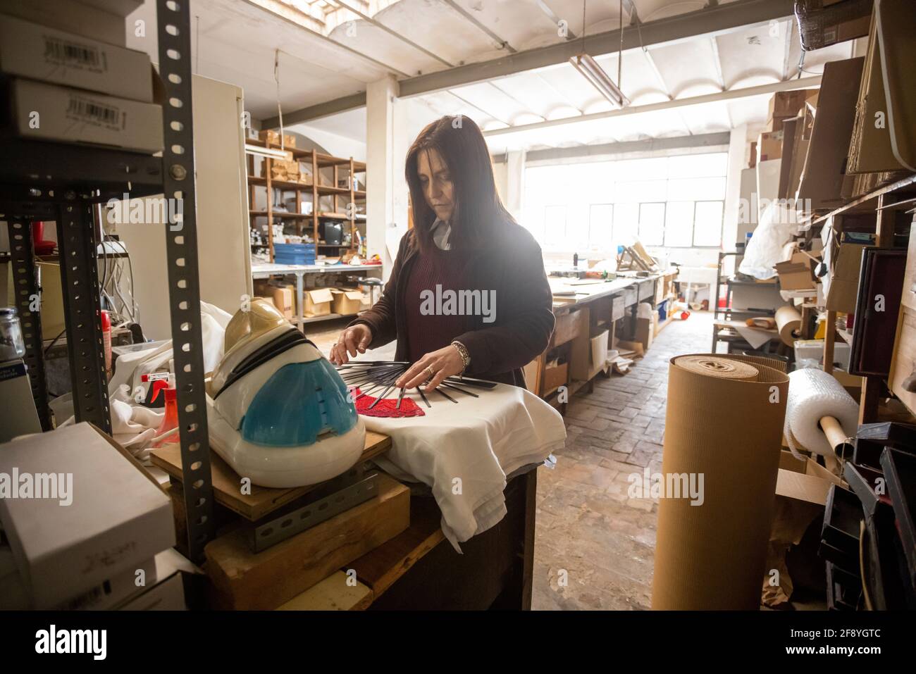 Donna spagnola che lavora in un laboratorio di progettazione di ventilatori a mano Foto Stock