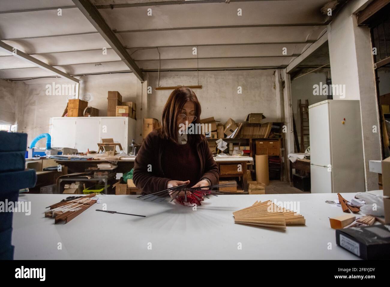 Donna spagnola che lavora in un laboratorio di progettazione di ventilatori a mano Foto Stock