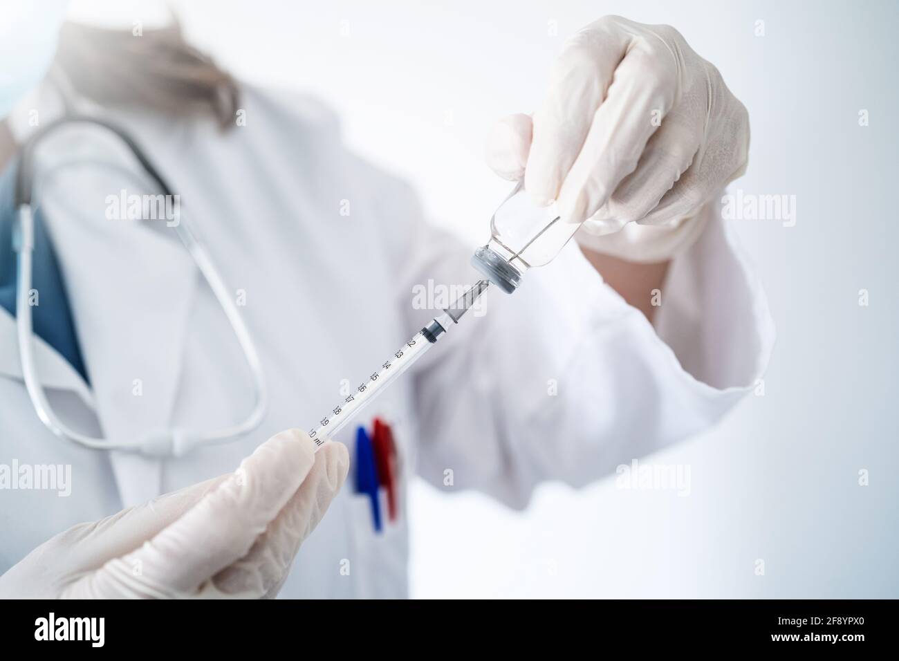 Chiuso di un medico che prepara un vaccino Covid-19 a. vaccinare i pazienti Foto Stock