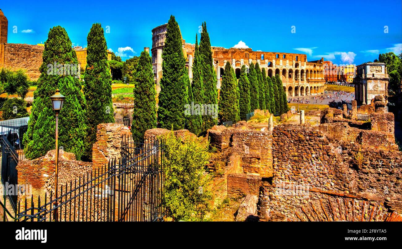 Antiche rovine con il Colosseo sullo sfondo, Roma, Italia Foto Stock