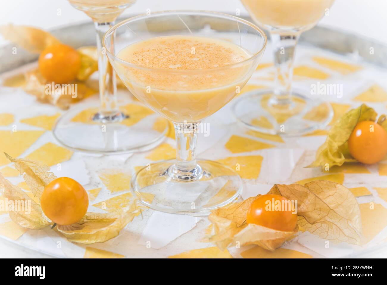 Bicchiere con egnog e frutti fisici su un vassoio rotondo Foto Stock