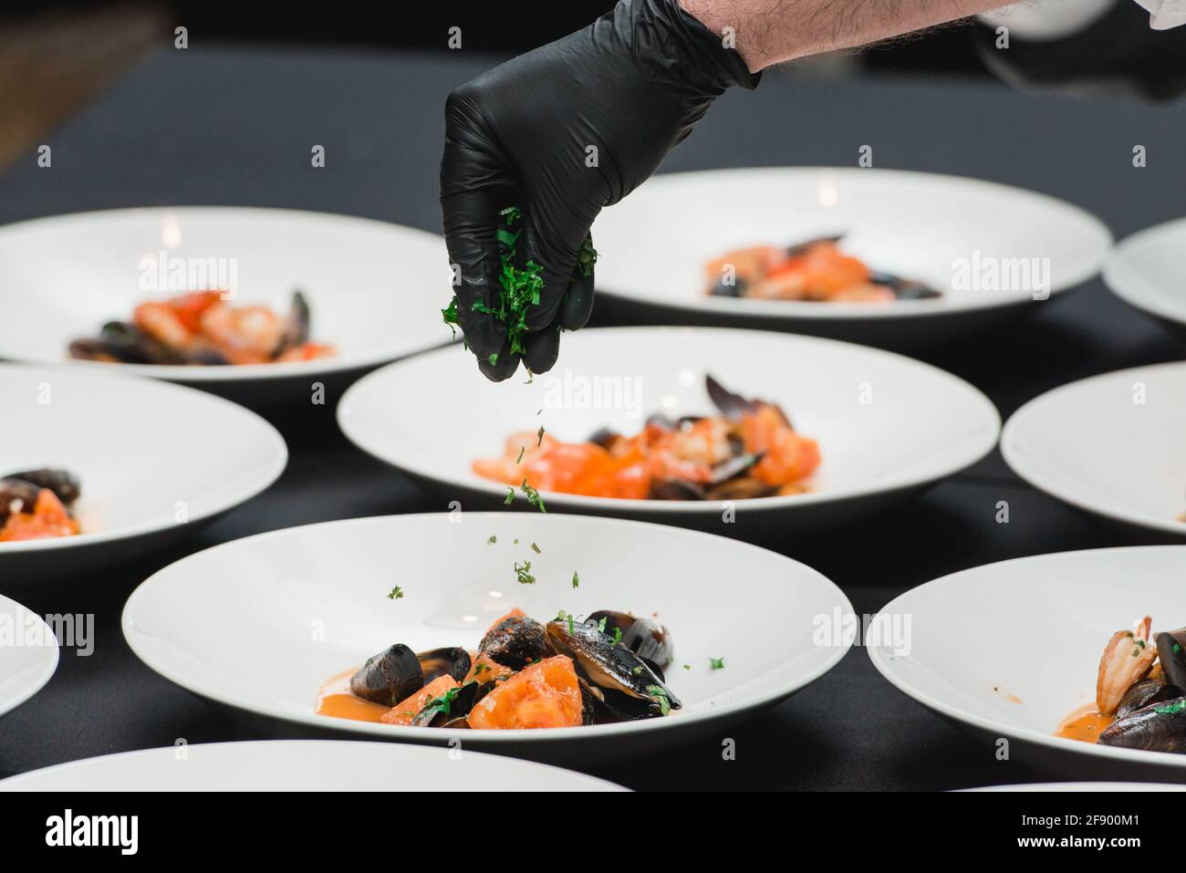 lo chef prepara un piatto di pesce e prepara il tavolo per il banchetto Foto Stock