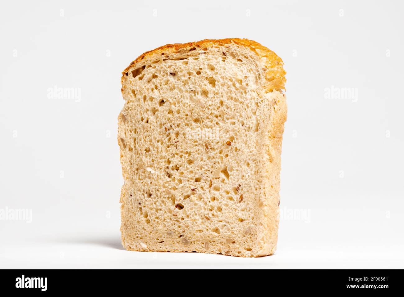 Vista laterale del pane a una fetta di semi misti su bianco Foto Stock