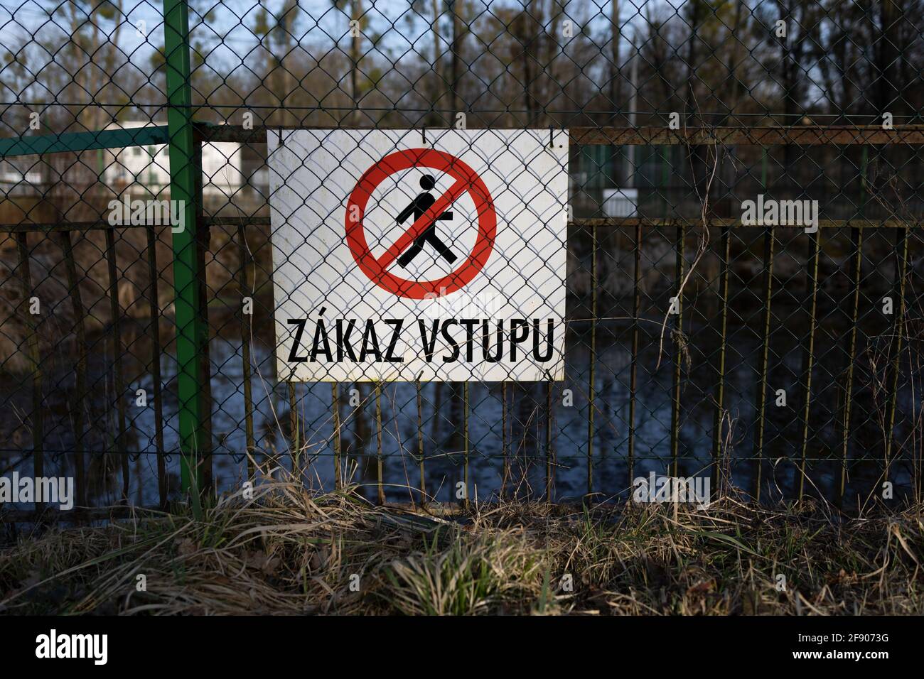 Zakaz vstuu (traduzione dal ceco: Nessun ingresso / nessuna entrata) - cartello, cartello e cartello sulla recinzione in rete metallica. Messa a fuoco superficiale. Foto Stock