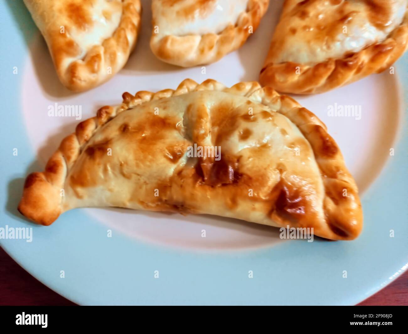 Empanadas argentino al forno. Un impasto sottile ripiegato su un ripieno di carne tritata, formaggio o verdure Foto Stock