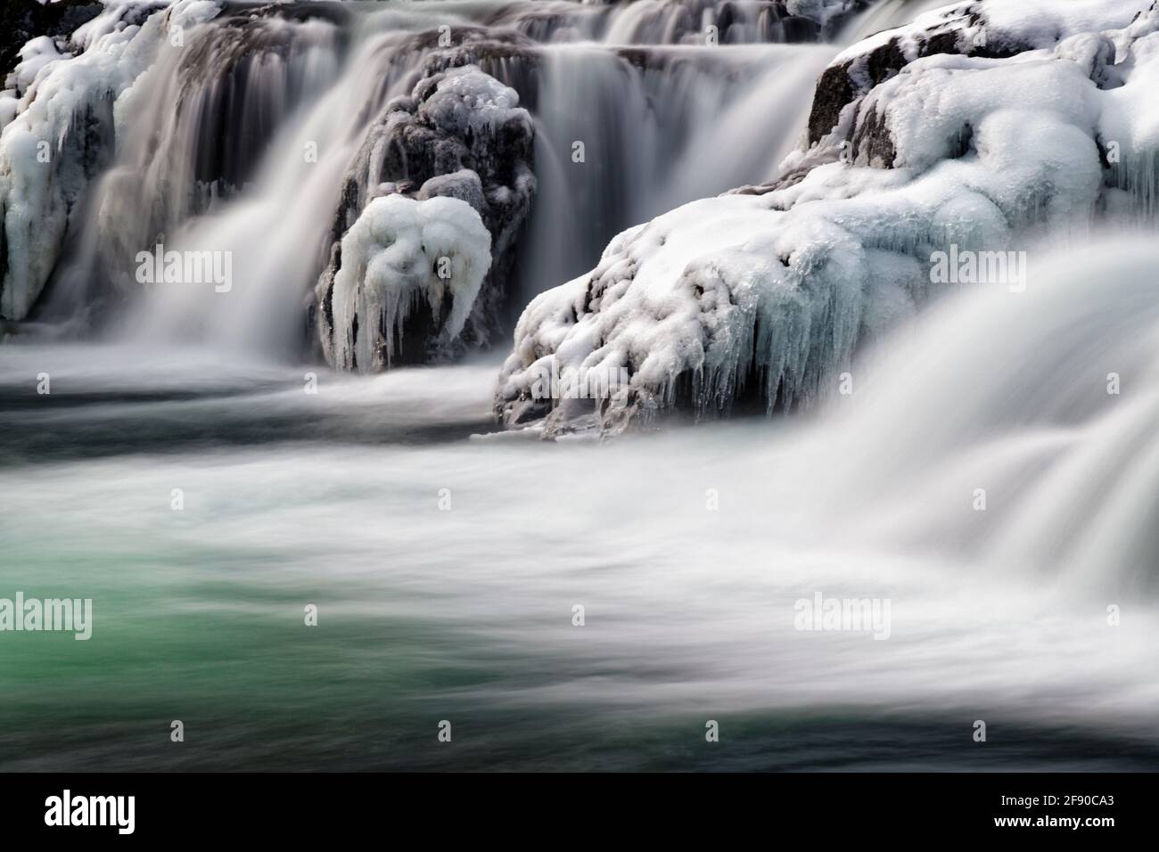 Lunga esposizione di paesaggio con cascata ghiacciata, Islanda Foto Stock