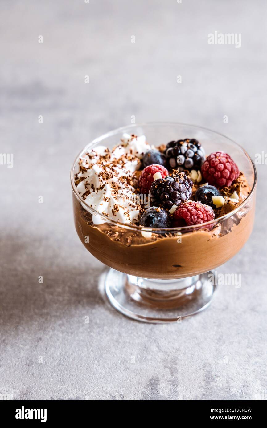 Mousse al cioccolato con panna montata, frutti di bosco e cioccolato bianco Foto Stock