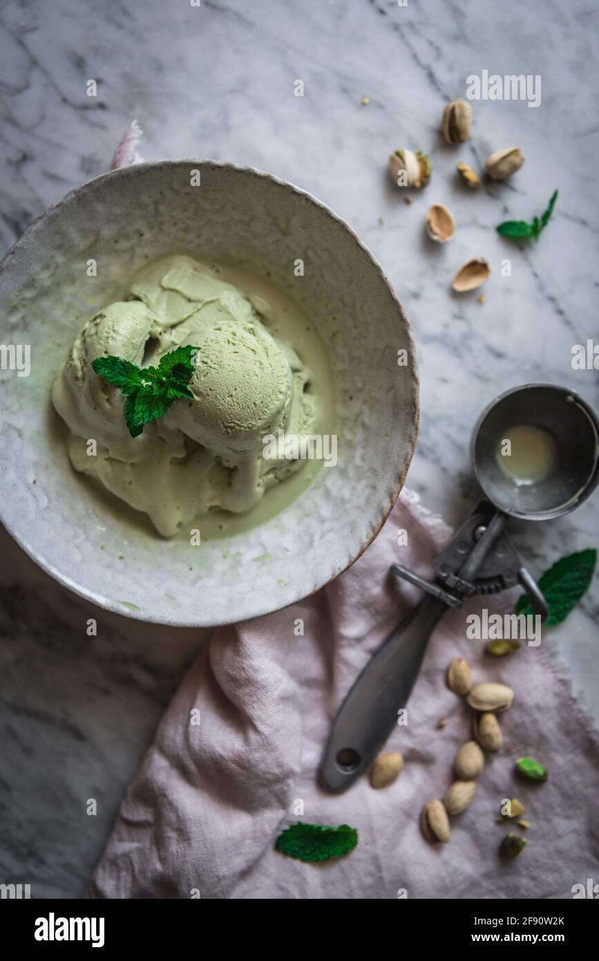 Gelato al pistacchio con paletta in una ciotola rustica Foto Stock