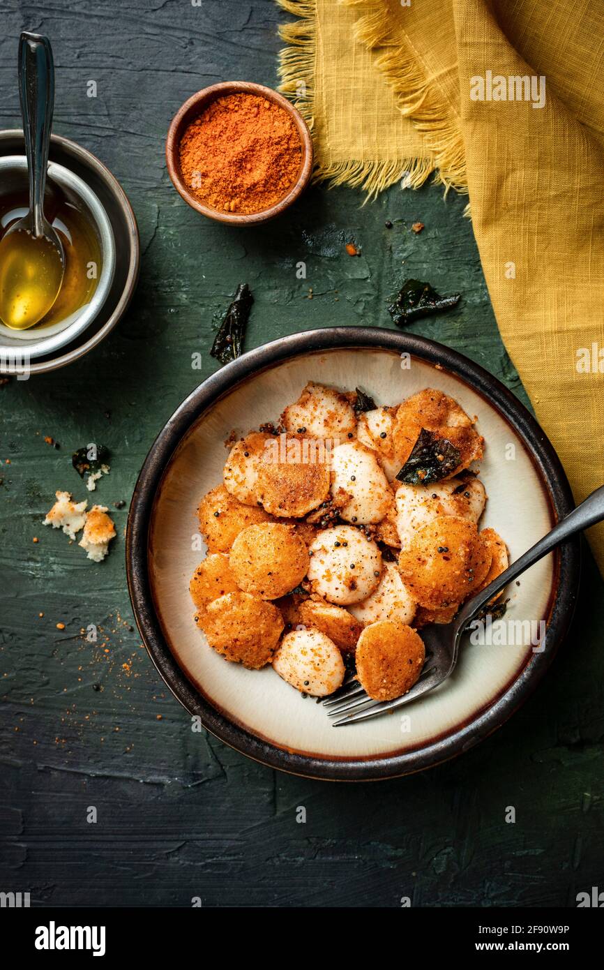 Colazione Mini-Idli servita con ghee e polvere. Foto Stock