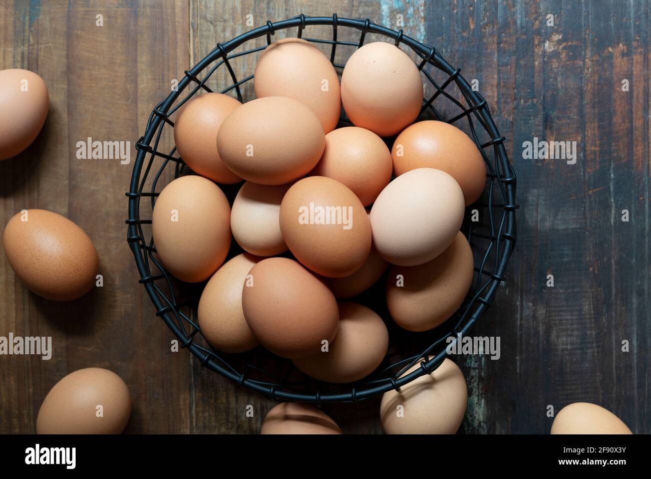 Far rosolare le uova di pollo in un cestello di filo. Foto Stock