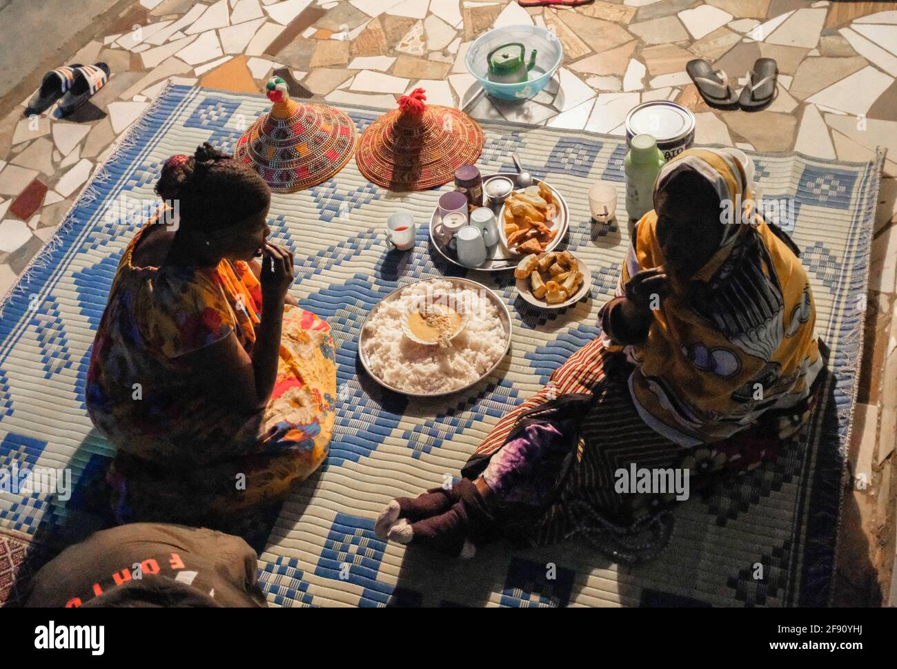 Fatuma Hussein (destra), di 66 anni, e sua figlia Zaria Hussein, godono del loro pasto speciale di iftar dopo il tramonto durante il mese di digiuno islamico del Ramadan a Kibera. Riguardo alle misure di contenimento in corso del Covid-19 a Nairobi per fermare la rapida diffusione del Coronavirus, La maggior parte dei fratelli e delle sorelle musulmani è oggi vista radunata nelle loro case con le loro famiglie per godere il loro secondo giorno di celebrare il loro mese santo di Ramadan con motivi di evitare le riunioni pubbliche e religiose. (Foto di Donwilson Odhiambo/SOPA Images/Sipa USA) Foto Stock