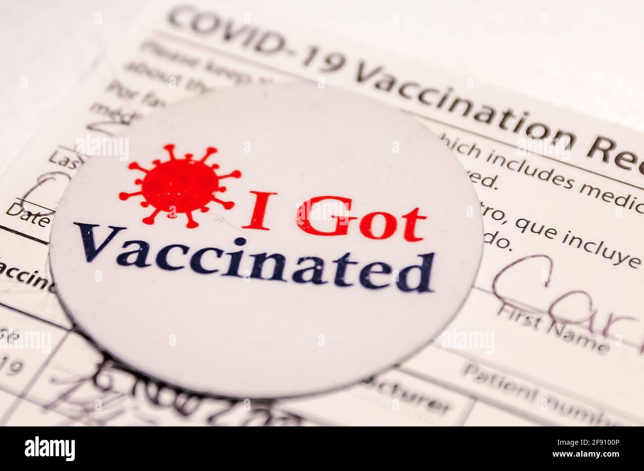 Un adesivo "sono stato vaccinato" è raffigurato con una scheda di vaccinazione COVID-19 dopo che un paziente ha ricevuto la prima dose del vaccino COVID-19 da parte di Pfizer. Foto Stock