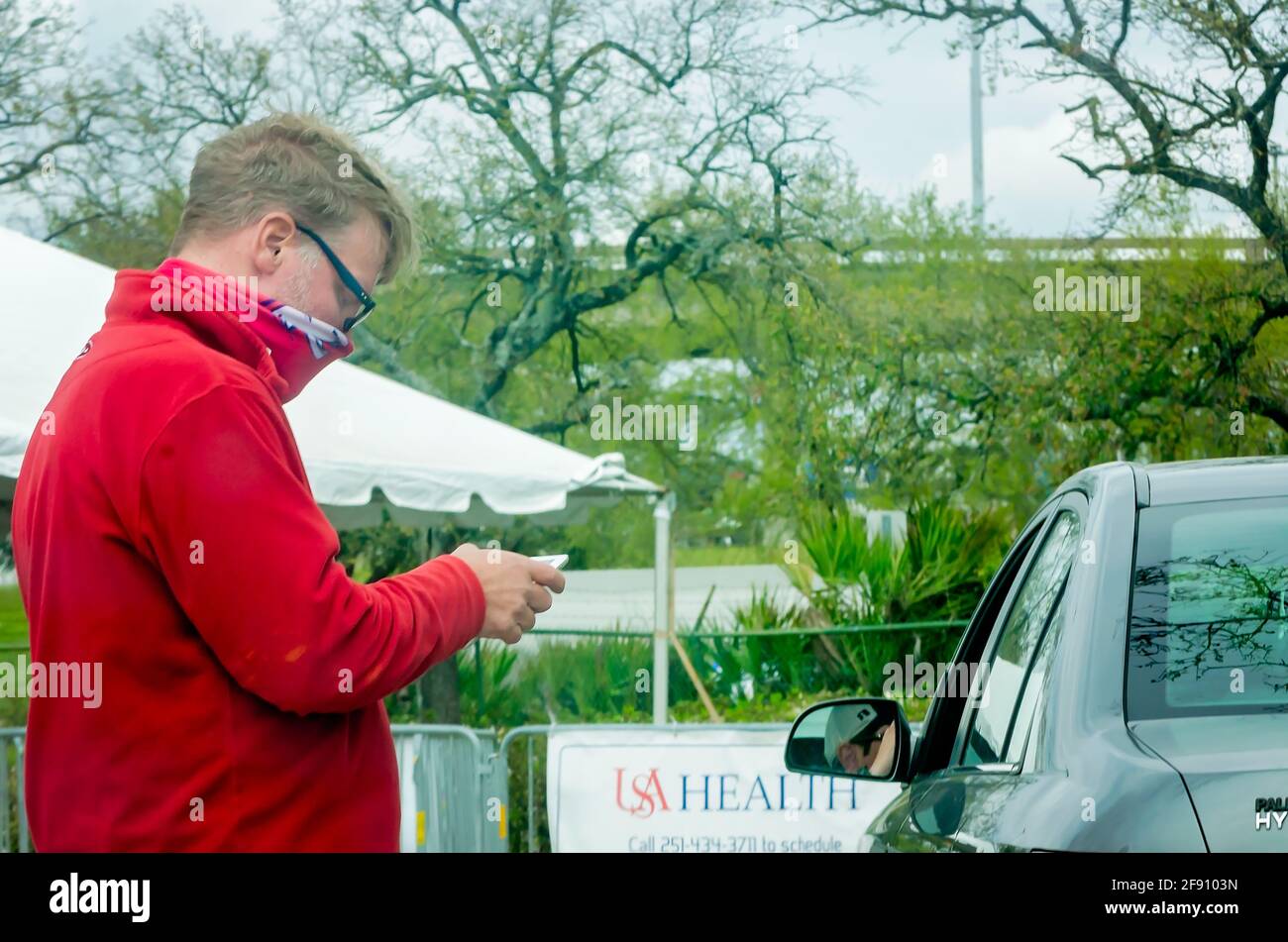 Un volontario della sanità degli Stati Uniti controlla i pazienti nel sito di vaccinazione drive-thru COVID-19 dell'ospedale presso il Mobile Civic Center di Mobile, Alabama. Foto Stock