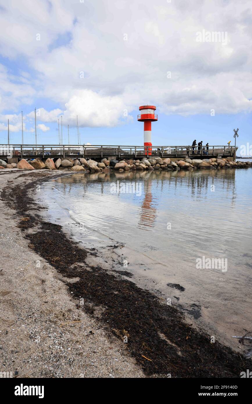 14 aprile 2021, Schleswig-Holstein, Eckernförde: Solo poche persone sono sul molo nel porto al faro alla punta del porto. Con l'aumento dei dati sulle infezioni, Schleswig-Holstein sta adottando misure caute per aprire il turismo, la cultura e lo sport nella crisi di Corona. (Al dpa: 'Il nuovo turismo inizia nel nord con un regime rigoroso e ritardi') Foto: Christian Charisius/dpa Foto Stock