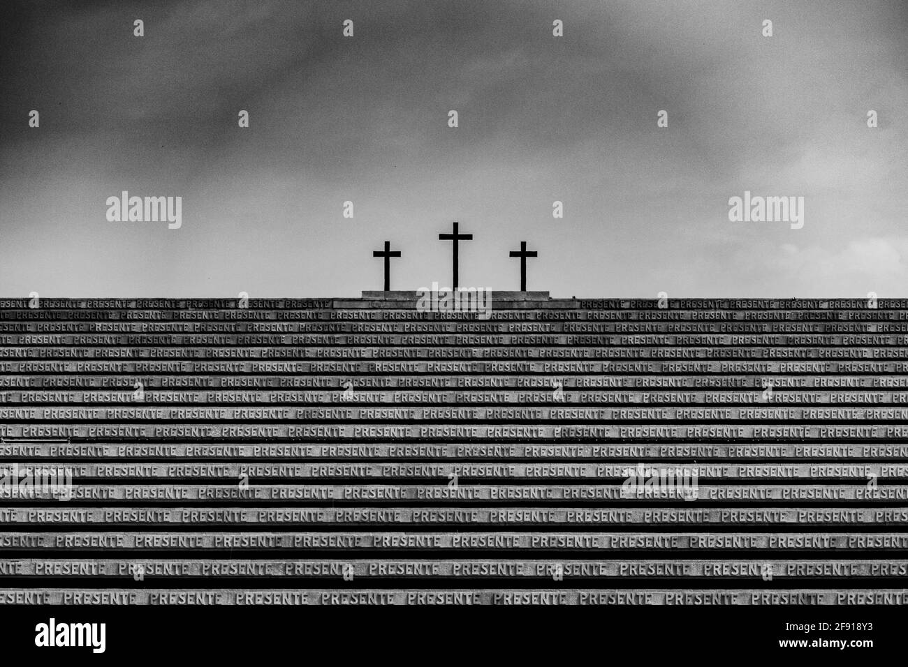 Vista in scala di grigi del Redipuglia War Memorial con tre croci sullo sfondo Foto Stock