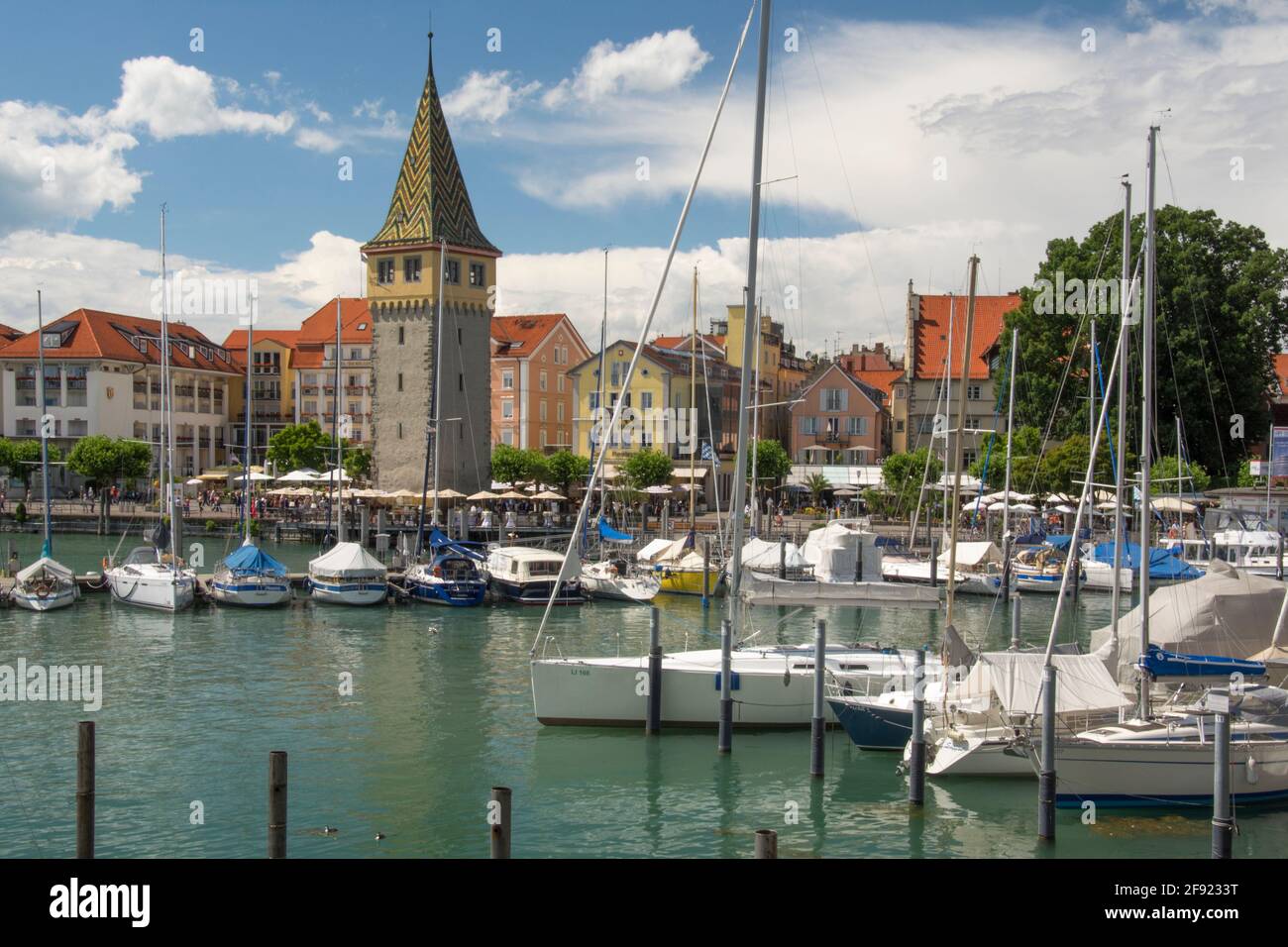 Lindau sul Bodensee (Lago di Costanza), Baviera, Germania meridionale. Il Mangturm del XIII secolo, con il suo tetto in tegole, è antenato all'attuale faro. Foto Stock