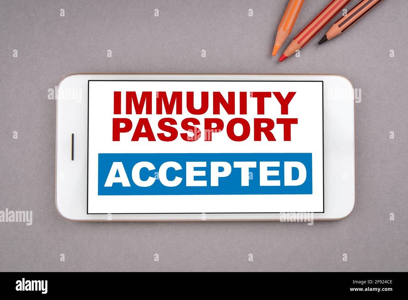 PASSAPORTO DELL'IMMUNITÀ ACCETTATO. Limitazioni di sollevamento e concetto di corsa libera. Telefono cellulare su sfondo grigio. Foto Stock