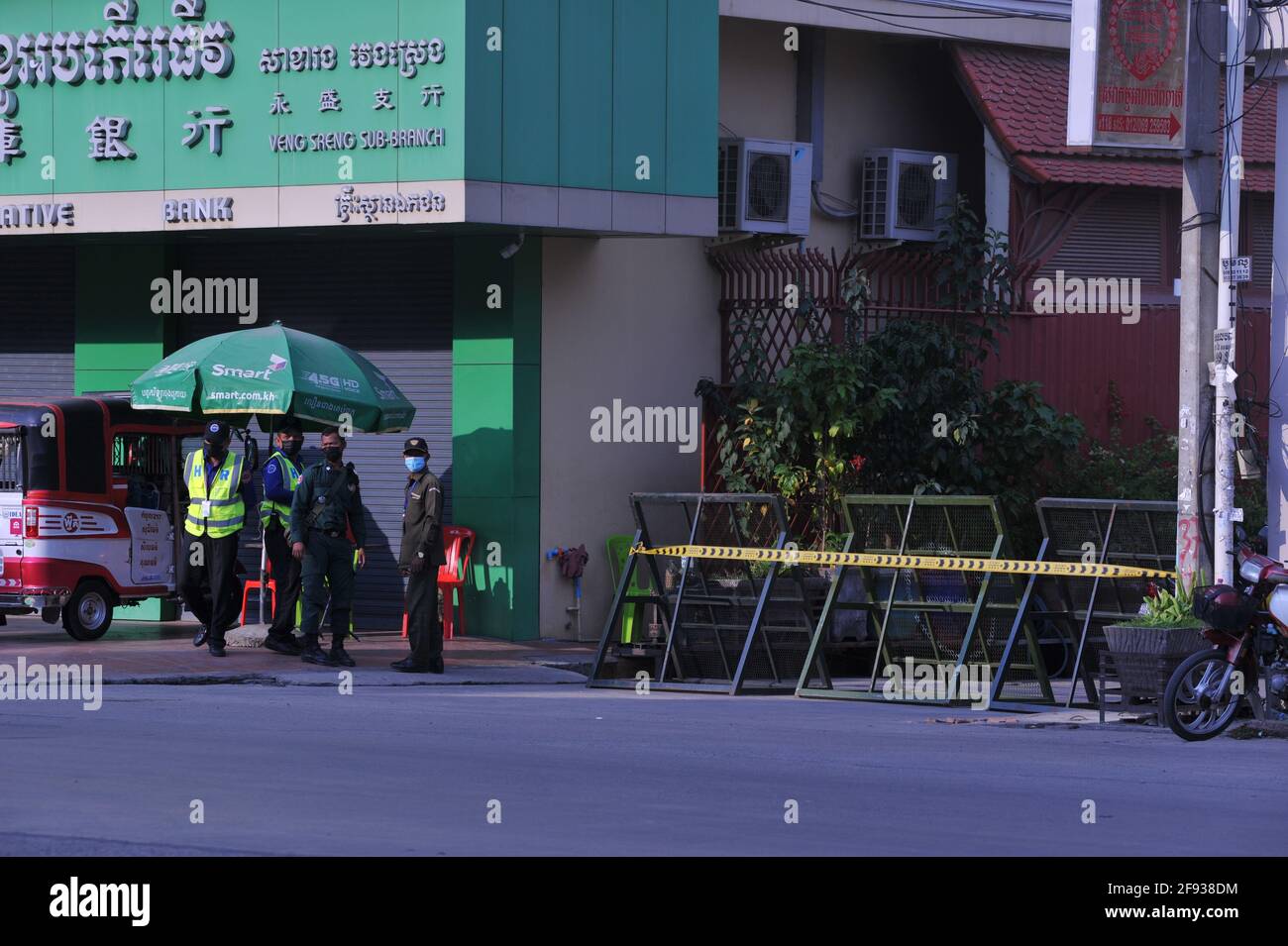 A causa di un recente scoppio di COVID - 19 in una fabbrica di abbigliamento, il governo cambogiano ha imposto un blocco, in cui sia la polizia che le guardie di sicurezza sono un checkpoint all'ingresso di una strada che è stata messa in quarantena durante la pandemia del coronavirus. Stueng Meanchey, Phnom Penh, Cambogia. 15 aprile 2021. © Kraig Lieb Foto Stock