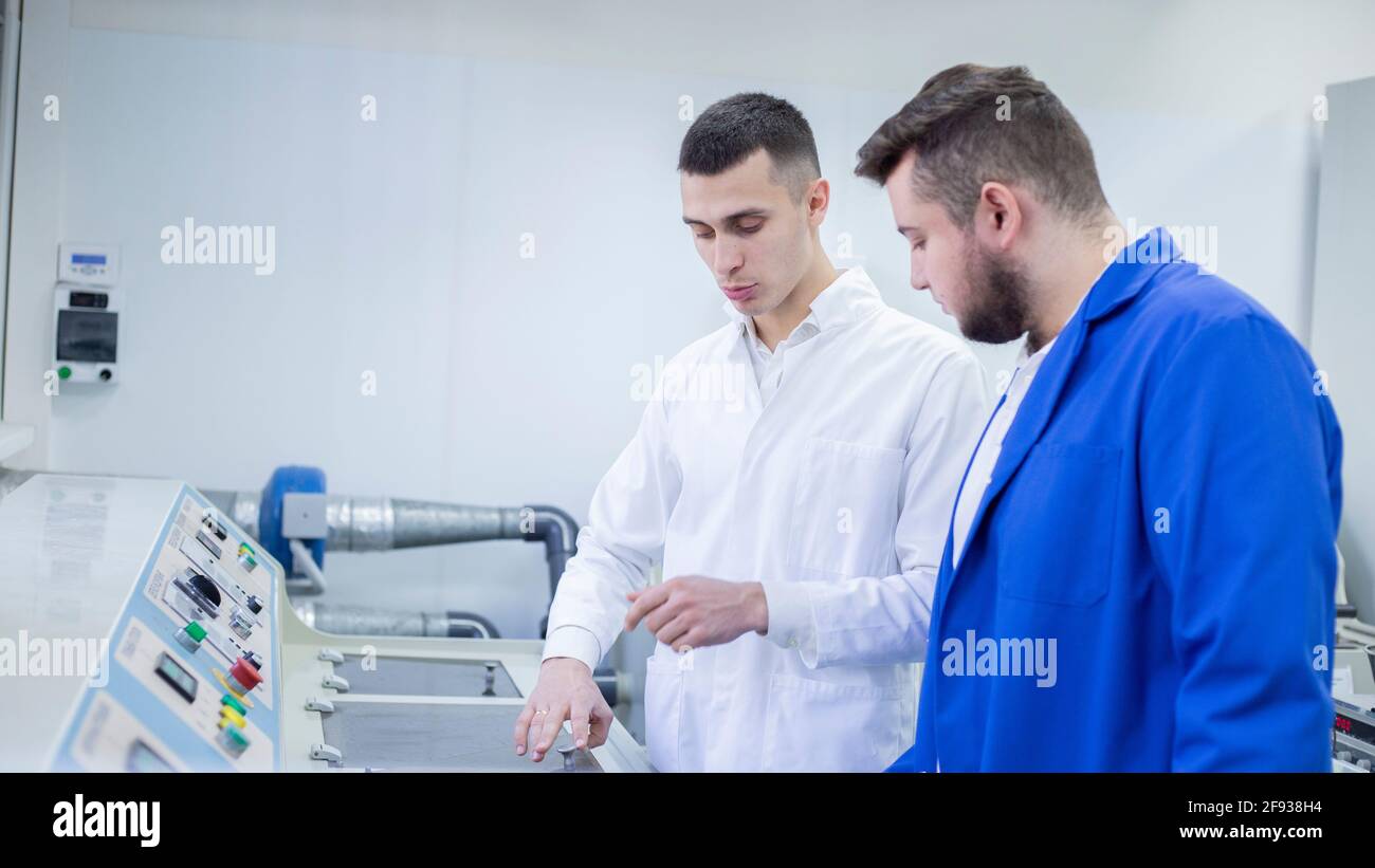 Progettista industriale e tecnico che esamina le attrezzature in fabbrica Foto Stock