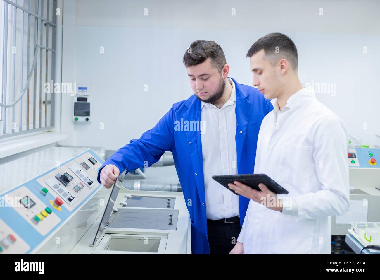 Progettista industriale e tecnico che esamina le attrezzature in fabbrica Foto Stock