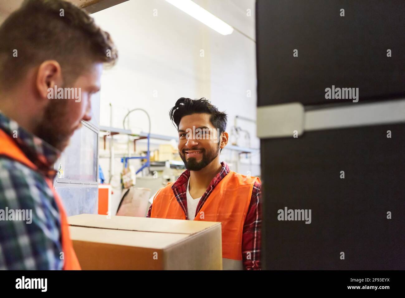 Addetto al magazzino con un pacco nel reparto consegna merci o nel reparto di spedizione di una fabbrica Foto Stock