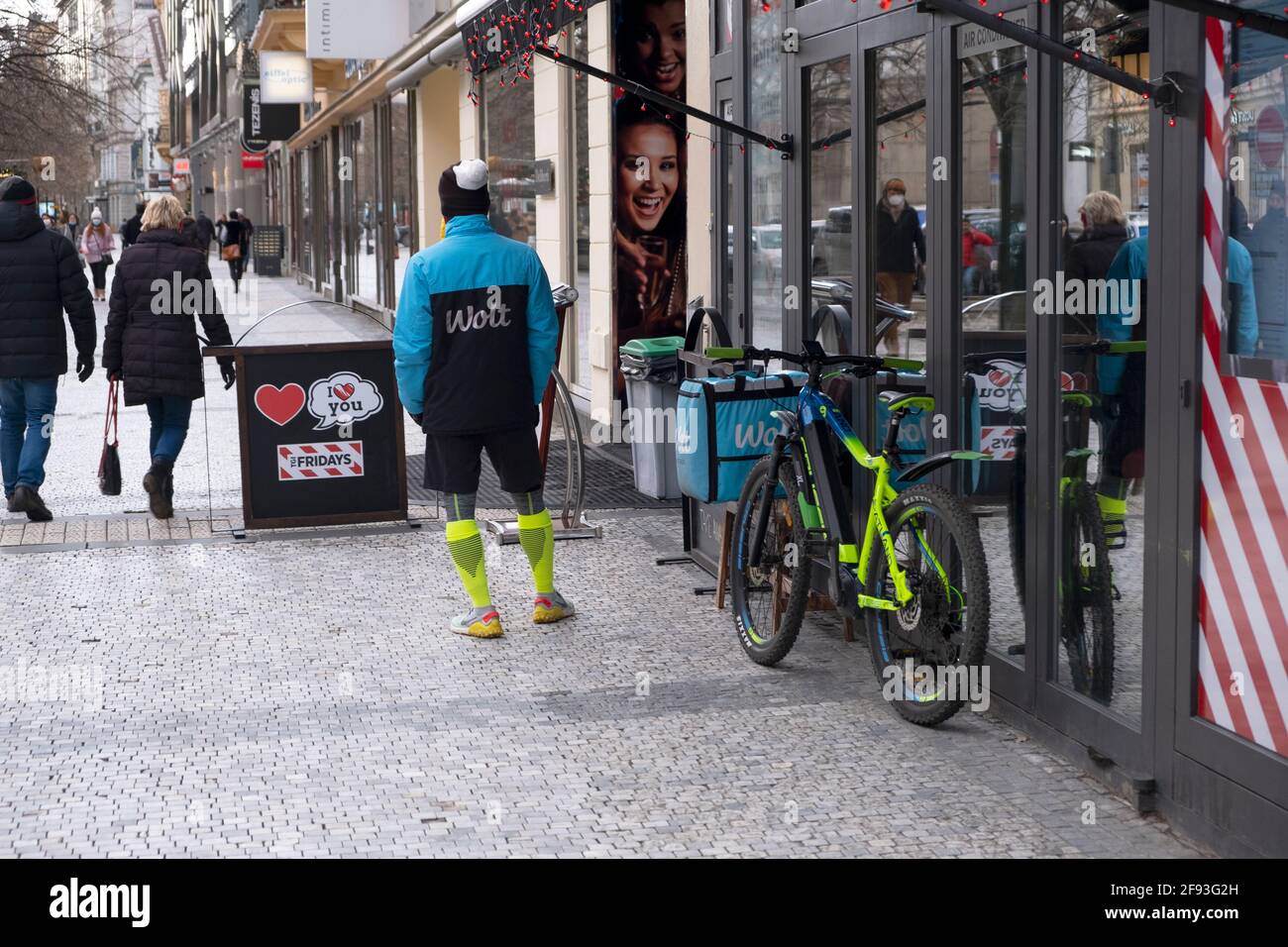 Praga, CZ - 13 gennaio 2021: Wolt azienda bike driver, fast-food consegna biker vicino alla sua Bike. Editoriale illustrativo Foto Stock