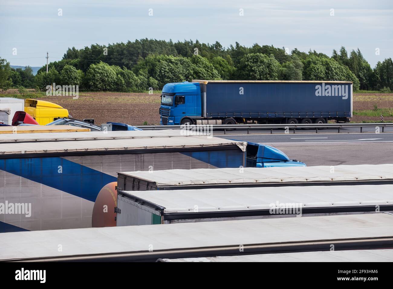 Autocarri pesanti nel parcheggio vicino all'autostrada Foto Stock