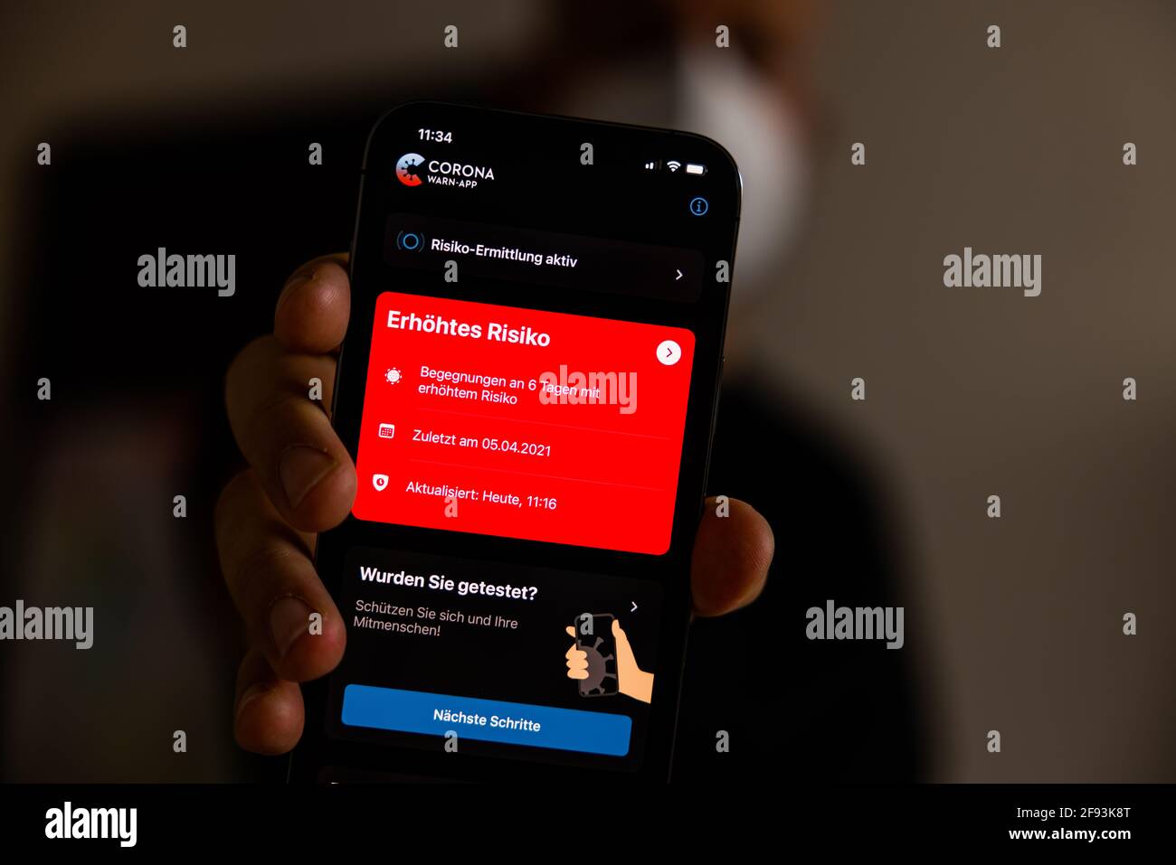 Düsseldorf, GERMANIA - Apr 15, 2021: Corona WARN-App Deutschland mit der roten erhoehten Risiko Warnmeldung ausschlagend. Foto Stock
