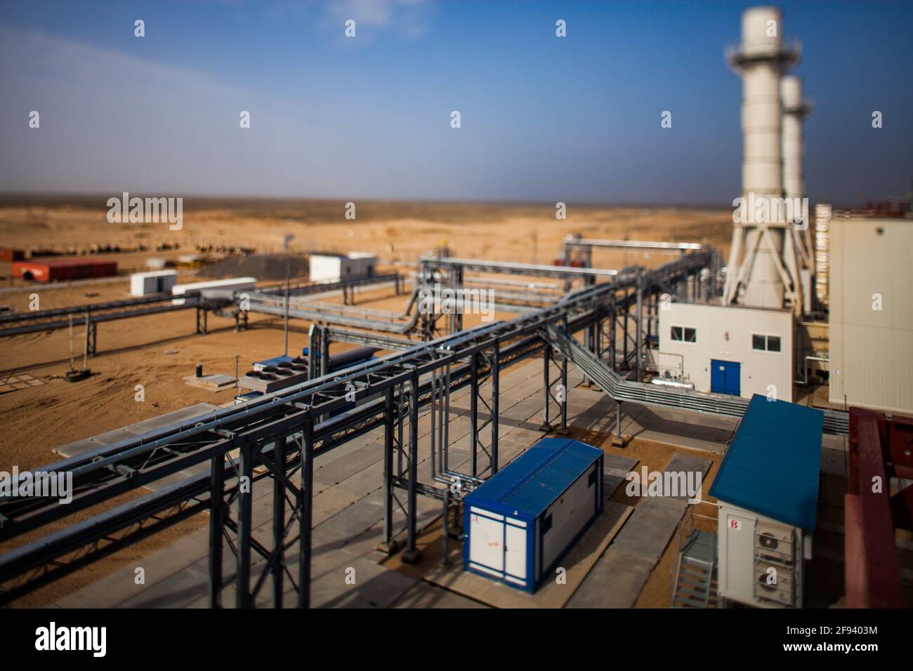Regione di Kzylorda/Kazakhstan - Maggio 01 2012: Moderna centrale a gas nel deserto. Immagine sfocata con effetto tilt-shift. Pipeline in primo piano. Cielo scuro e voi Foto Stock