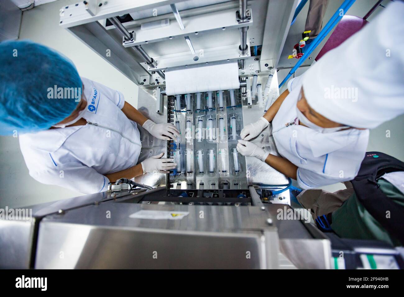 Atyrau, Kazakistan. Impianto di produzione di siringhe mediche. Due operatori femminili asiatici sulla linea di produzione. Foto Stock