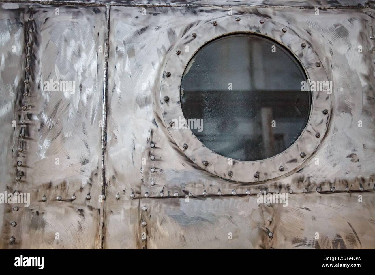 Impianto di costruzione di navi. Pozzetto in metallo graffiato e non verniciato con illuminatore a foro di vetro. Foto Stock