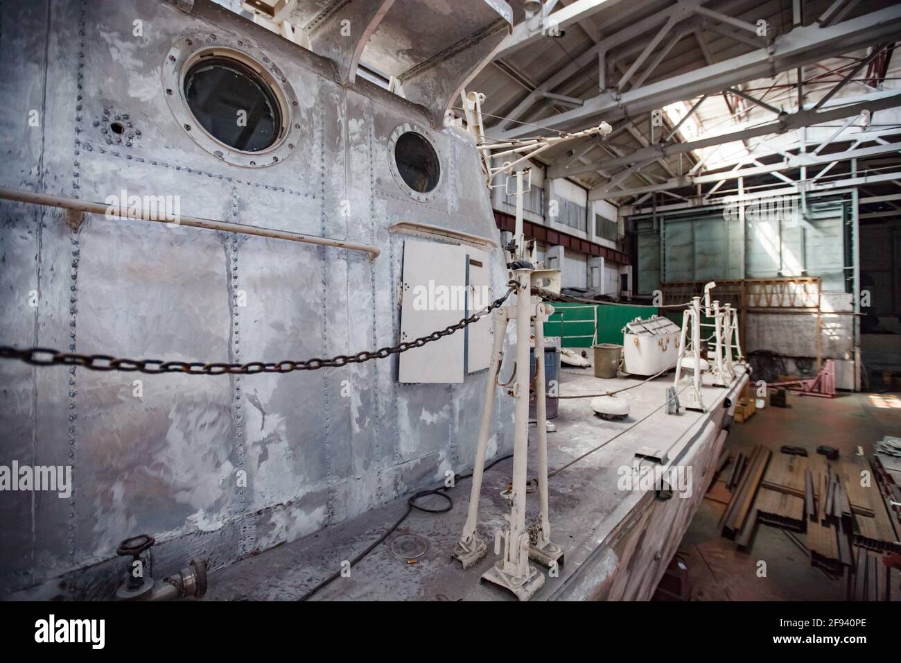 Impianto di costruzione di navi. Pozzetto in metallo graffiato e non verniciato con illuminatori a foro di vetro. Foto Stock