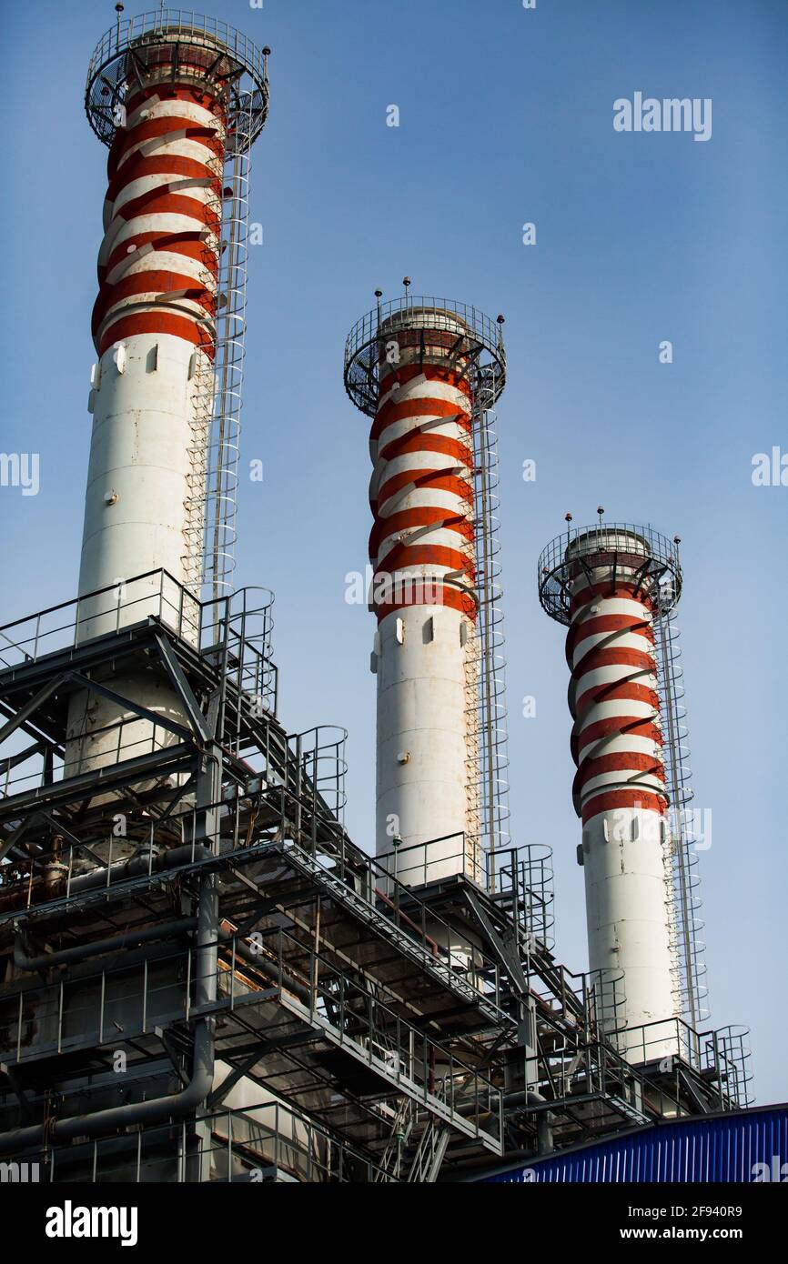 Pile di fumo rosse e bianche a strisce (camini di piante) su sfondo blu del cielo. Moderna centrale a gas. Primo piano. Foto Stock